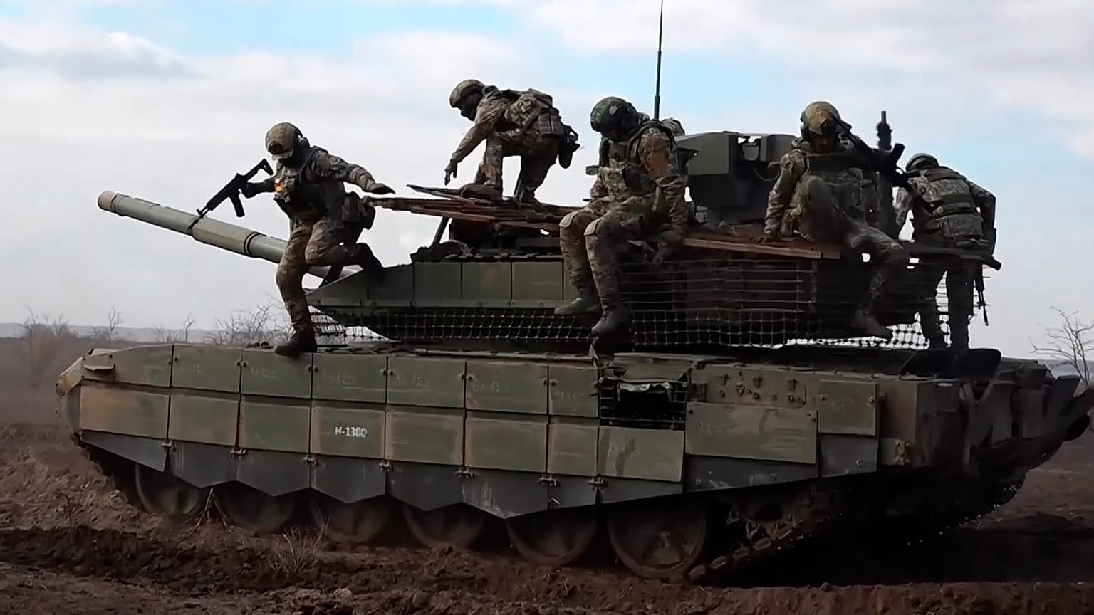 Orosz katonák egy T-90M Proriv típusú harckocsiról ugranak le bevetés előtti gyakorlatozáson egy meg nem nevezett helyszínen 2024. november 27-én. 