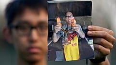Harrison Li, Kaliforniya'da bir fotoğraf için poz verirken babası Kai Li'nin bir fotoğrafını tutuyor, 23 Ocak 2024