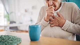 An older woman coughs.