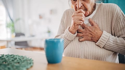 An older woman coughs.