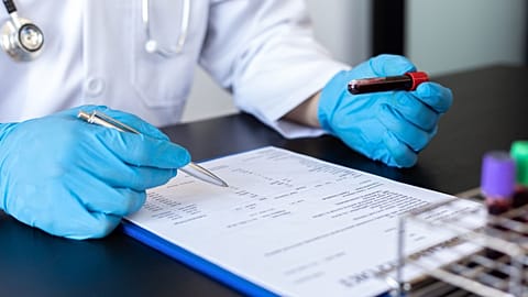 A doctor reviews a blood sample.