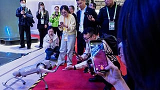 Látogatók egy robotot vizsgálnak az expón