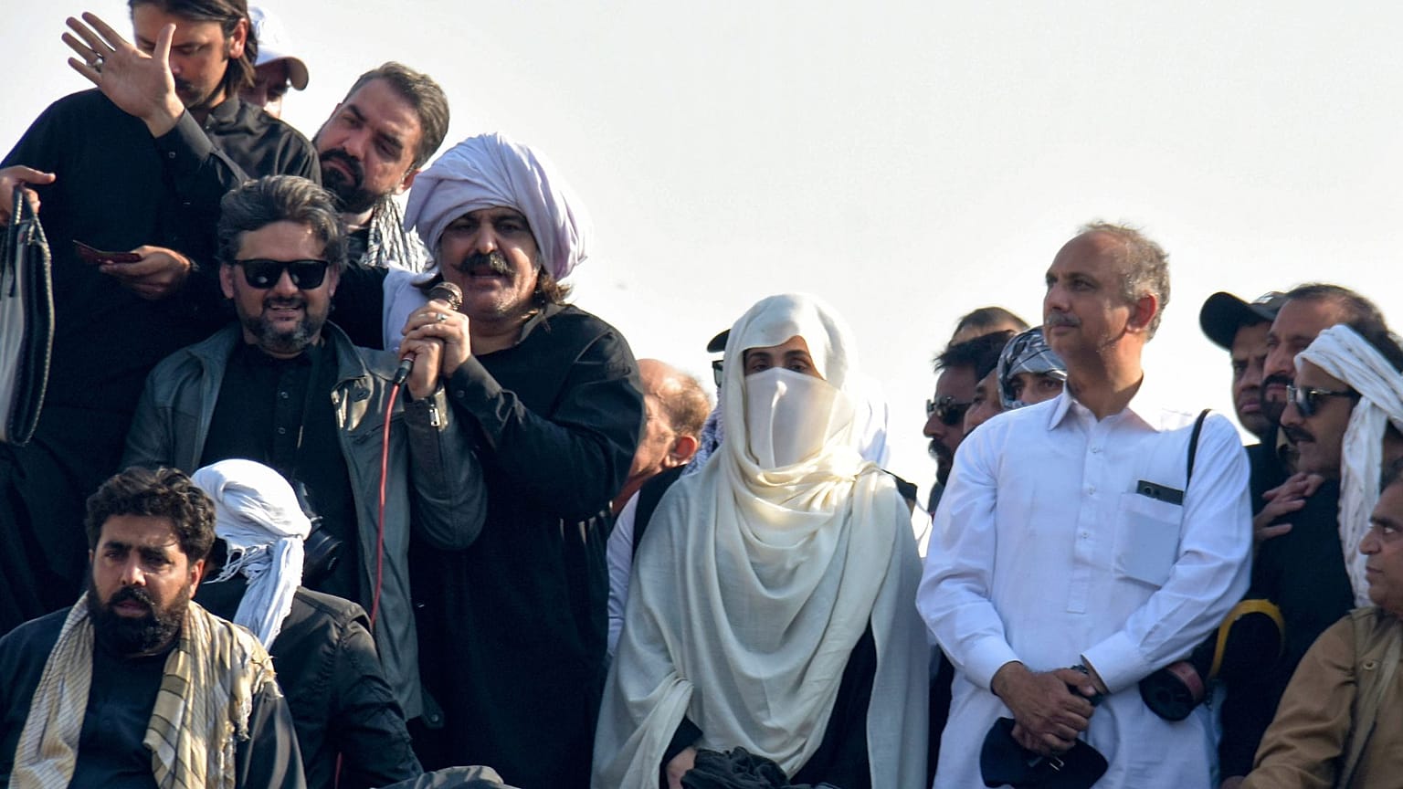 Bushra Bibi, ao centro, mulher do antigo primeiro-ministro Imran Khan, que está preso, e dirigentes do partido de Khan lideram os seus apoiantes durante um comício em 26 de novembro de 2024.