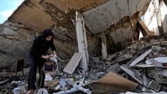 امرأة تقف أنقاض منزلها المدمر بعد عودتها إلى قريتها في بلدة حناويه، جنوب لبنان، الخميس، 28 نوفمبر/تشرين الثاني 2024،