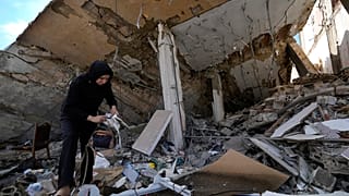 امرأة تقف أنقاض منزلها المدمر بعد عودتها إلى قريتها في بلدة حناويه، جنوب لبنان، الخميس، 28 نوفمبر/تشرين الثاني 2024،