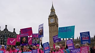 Une petite manifestation de personnes prônant l'aide à la mort se tient devant les cornes du Parlement, 2024.