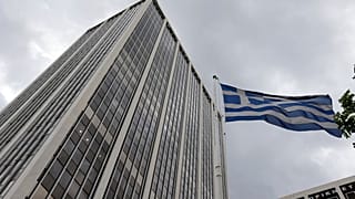 A Greek flag waves outside an office building in Athens, Friday, June 5, 2014.