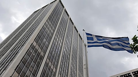 A Greek flag waves outside an office building in Athens, Friday, June 5, 2014.