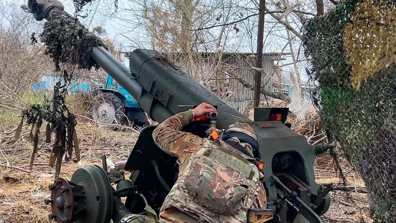 Un militare russo punta un D-30 verso le posizioni ucraine nella zona di confine della regione di Kursk, Russia