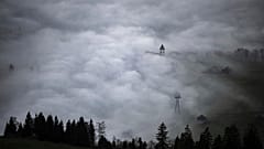 A church tower rises through the fog in Bruelisau, Switzerland. 4 November 2024.
