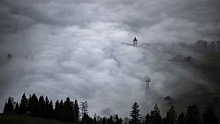 A church tower rises through the fog in Bruelisau, Switzerland. 4 November 2024.