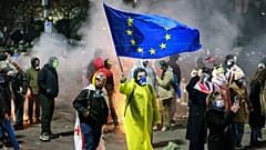 Egy tüntető uniós zászlót lenget a parlament előtti tüntetésen Tbilisziben, 2024. november 30.