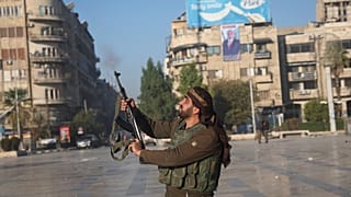 Suriyeli bir muhalif savaşçı 30 Kasım 2024 Cumartesi günü Suriye'nin Halep kent merkezinde havaya ateş açıyor. (AP Fotoğrafı/Ghaith Alsayed)
