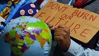 A demonstrators holds a sign that reads "don't burn our future" at the COP29 U.N. Climate Summit, Monday, Nov. 18, 2024, in Baku, Azerbaijan.