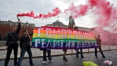 Activistas por los derechos de los homosexuales sostienen una pancarta en la que se lee Homofobia - la religión de los matones durante su acción de protesta.