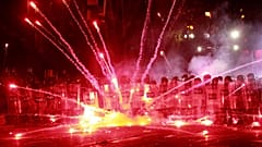 Göstericiler, 1 Aralık 2024 Pazar günü erken saatlerde Gürcistan'ın Tiflis kentindeki parlamento binası dışında polise fişek atıyor