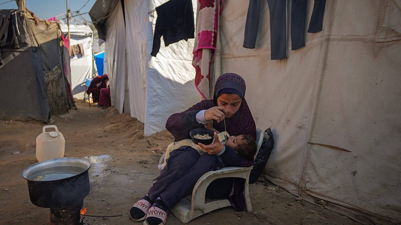 16 yaşındaki Asma El-Harobi, Gazze Şeridi'ndeki yerinden edilmiş Filistinliler için kurulan kampta 10 aylık kız kardeşine suyla karışık süt içiriyor, 1 Aralık, 2024.