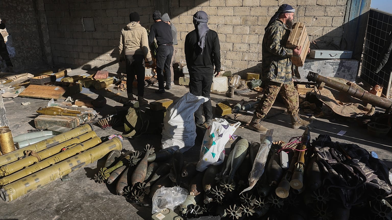 Combattenti ribelli siriani sequestrano munizioni abbandonate dell'esercito siriano nella città di Khan Assubul, Siria, sud-ovest di Aleppo, domenica 1 dicembre 2024.