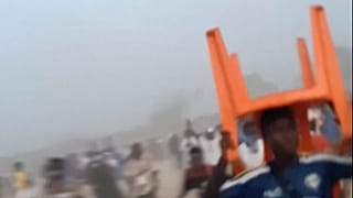 لقطة مأخوذة من مقطع فيديو يظهر رجل يحمل كرسيًا فوق رأسه أثناء التدافع، خلال مباراة كرة قدم في ملعب نزيريكوري في نزيريكوري، غينيا يوم الأحد، 1 ديسمبر/كانون الأول 2024.