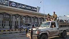  مقاتلون من المعارضة السورية يستقلون شاحنة صغيرة في مطار حلب الدولي في حلب، يوم الاثنين 2 ديسمبر/كانون الأول 2024. 