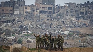 Ισραηλινές στρατιώτες στο νότιο Ισραήλ με φόντο τα συντρίμμια στη Γάζα