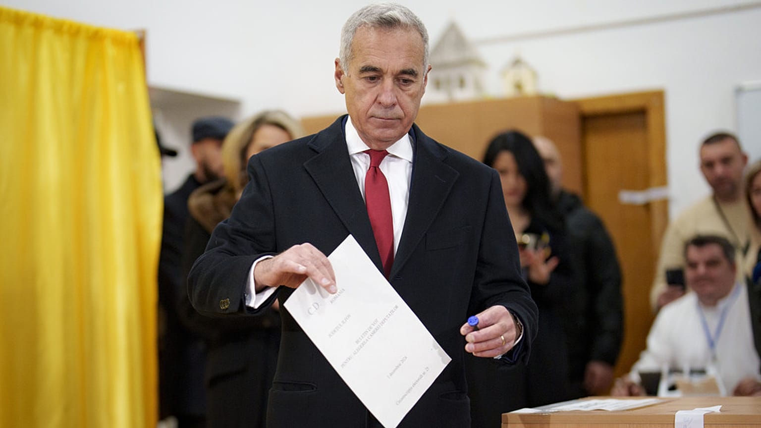 Calin Georgescu, candidato independente à presidência, vota nas eleições legislativas do país, em Mogosoaia, Roménia, domingo, 1 de dezembro de 2024