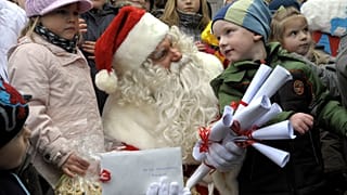 Egy Mikulás-jelmezbe öltözött férfi beszél a gyerekekkel az észak-brandenburgi Himmelpfort faluban 2009. november 10-én