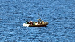 Una patera llena de migrantes en medio del mar.