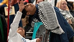 Nasser, 8 ans, à gauche, parle avec Diaa Al-Adini, à droite, après son arrivée à l'aéroport international de Portland, Oregon, USA, le 02.12.2024