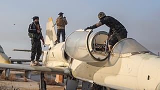 جنگجویان ضد حکومت مرکزی سوریه پس از کنترل تأسیسات در حومه حلب، روی یک هواپیما در فرودگاه نظامی النیرب، ۲ دسامبر ۲۰۲۴ 