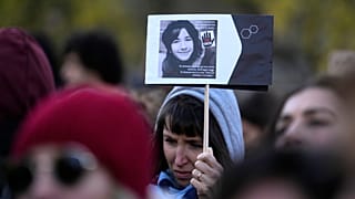 Une femme montre une photo de Giulia Cecchettin à l'occasion de la Journée internationale contre les violence envers les femmes, à Milan, Italie, le samedi 25 novembre 2023.
