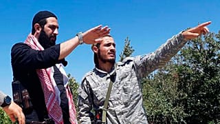  أبو محمد الجولاني زعيم هيئة تحرير الشام وزعيم فرع تنظيم القاعدة في سوريا يتحدث مع أحد المقاتلين في ريف اللاذقية