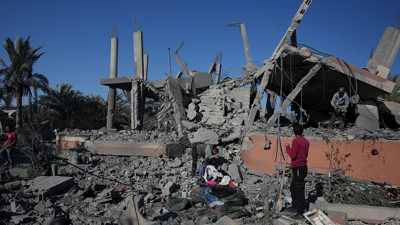 فلسطينيون يتفقدون أنقاض مبنى مدمر بعد غارة إسرائيلية ليلية في دير البلح بقطاع غزة، الأربعاء، 4 ديسمبر/كانون الأول 2024