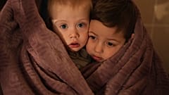 Die Kinder von medizinischem Personal wärmen sich in einer Decke, während sie in einem Krankenhaus in Mariupol, Ukraine, am Freitag, 4. März 2022, auf ihre Angehörigen warten.
