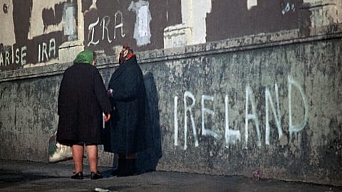 FILE: Women chat on a pavement against a background of political slogans written on a wall in Belfast, Northern Ireland in 1972. 