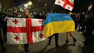 Göstericiler 3 Aralık 2024 Salı günü Gürcistan'ın başkenti Tiflis'te düzenlenen protesto sırasında Gürcistan ve Ukrayna ulusal bayraklarını tuttu.