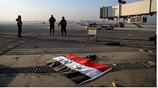پرچم سوریه بر روی باند فرودگاه حلب در حالیکه شورشیان در تاریخ دوم دسامبر ۲۰۲۴ در کنار آن ایستاده‌اند 