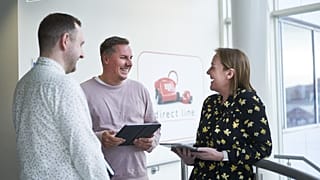 Direct line stock photo. Colleagues laughing in an office.