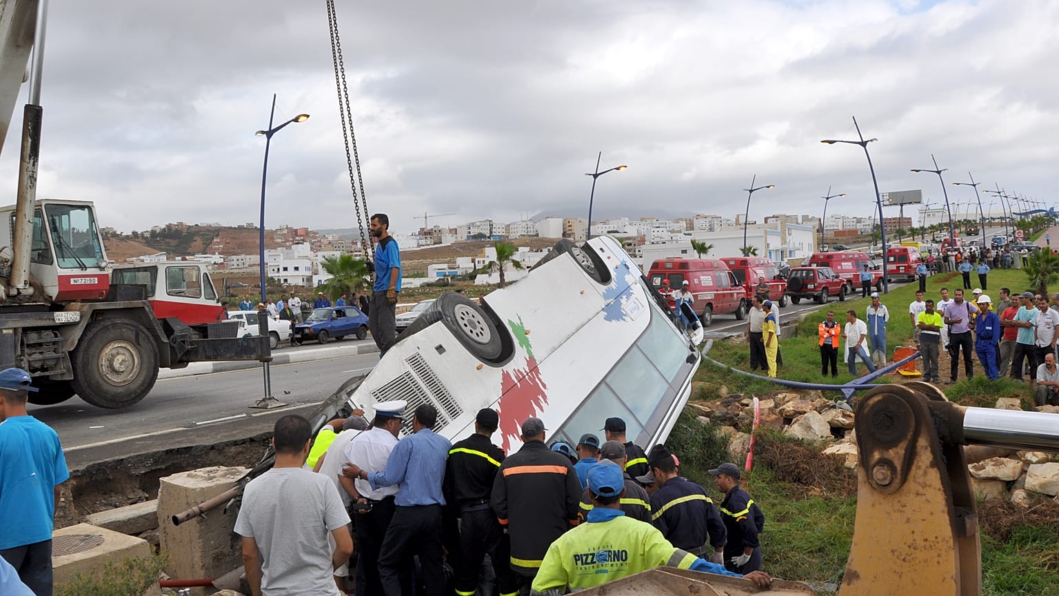 عمال الإنقاذ ينقلون حافلة سياحية مقلوبة من أحد الوديان بمساعدة رافعة في شمال المغرب يوم الأربعاء 8 سبتمبر 2010
