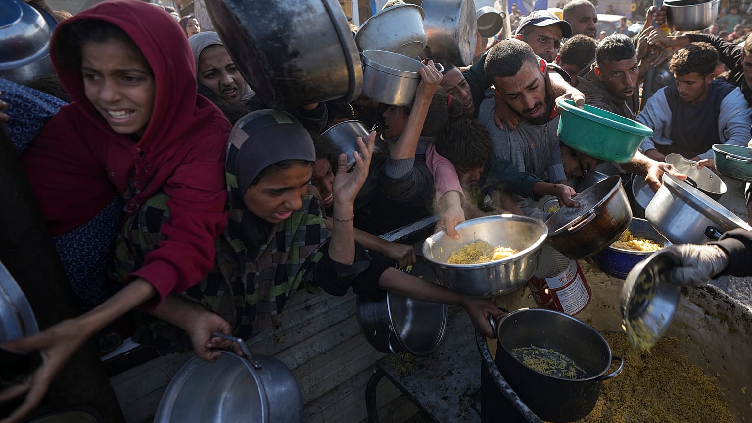  فلسطينيون يكافحون للوصول إلى الطعام في مركز توزيع في خان يونس بقطاع غزة يوم الجمعة، 6 ديسمبر 2024