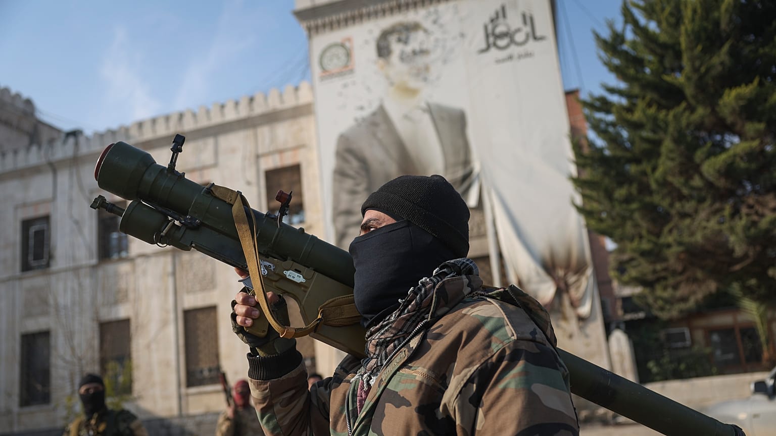 Un combattant de l'opposition syrienne tient un lance-roquettes devant le bureau du gouvernement provincial à Hama, le vendredi 6 décembre 2024.
