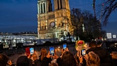 أشخاص يلتقطون صوراً لكاتدرائية نوتردام قبل يوم واحد من إعادة افتتاحها في باريس يوم الجمعة، 6 ديسمبر 2024.
