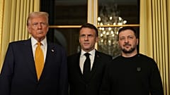 O Presidente francês Emmanuel Macron, ao centro, posa com o Presidente eleito Donald Trump, à esquerda, e o Presidente da Ucrânia, Volodymyr Zelenskyy, no Palácio do Eliseu