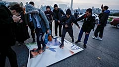 Сирийцы празднуют прибытие бойцов оппозиции, растаптывая фотографию президента Сирии Башара Асада в Дамаске, Сирия, воскресенье, 8 декабря 2024 года.