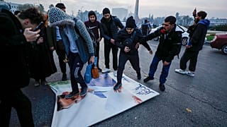Сирийцы празднуют прибытие бойцов оппозиции, растаптывая фотографию президента Сирии Башара Асада в Дамаске, Сирия, воскресенье, 8 декабря 2024 года.