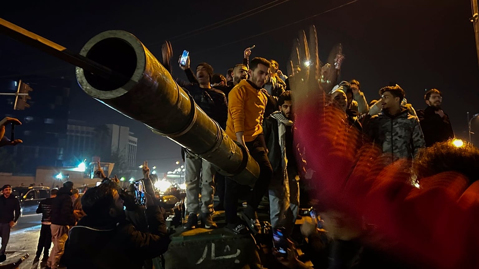 Sírios celebram a chegada de combatentes da oposição em Damasco, na Síria, no domingo, 8 de dezembro de 2024.