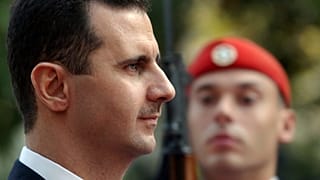 ARQUIVO - O Presidente sírio Bashar Assad passa em revista a guarda presidencial durante a cerimónia de boas-vindas em Atenas, a 15 de dezembro de 2003.