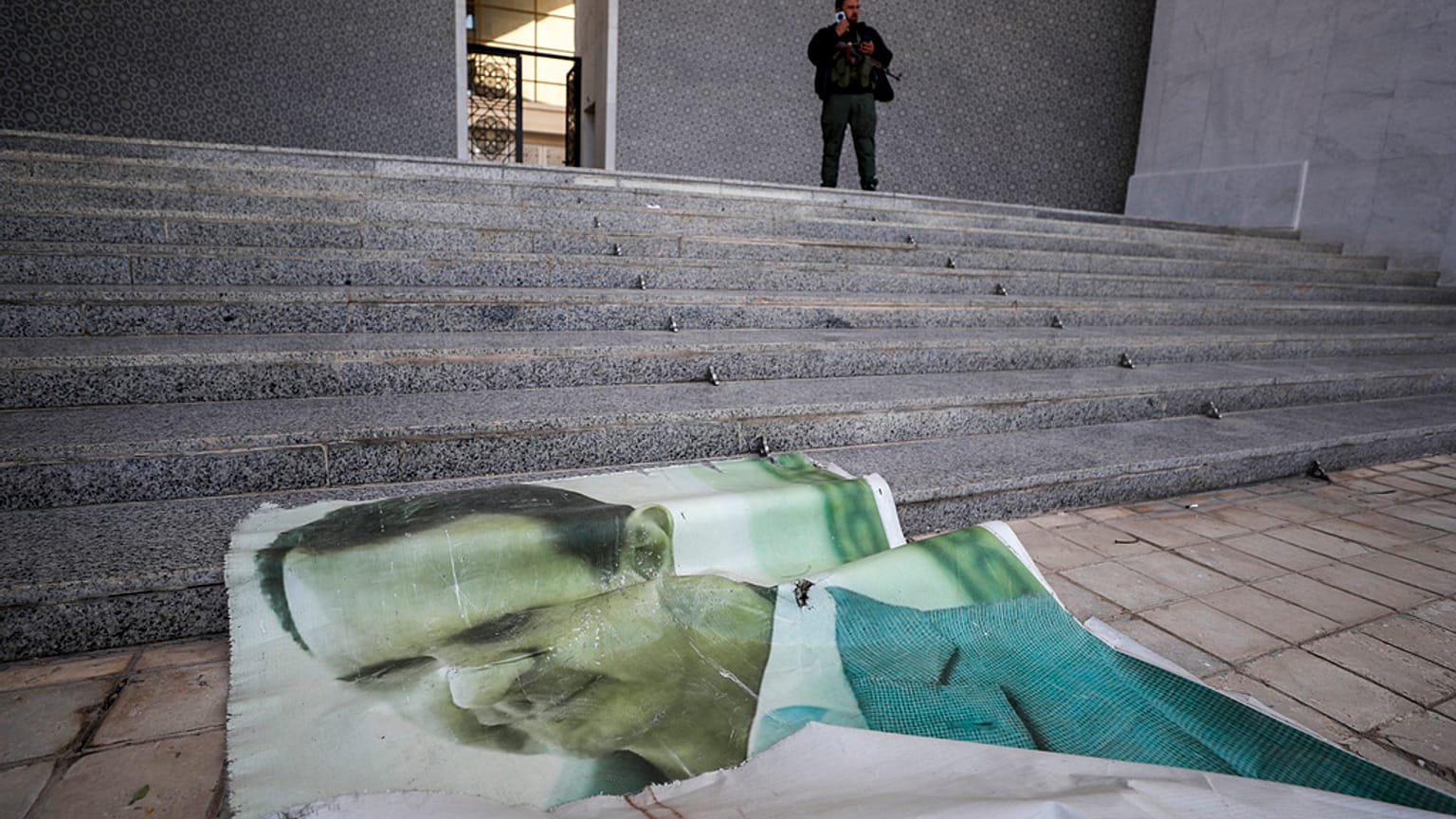 Poster di Bashar al-Assad distrutto a Damasco