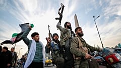 Des combattants de l'opposition syrienne célèbrent l'effondrement du gouvernement syrien à Damas.
