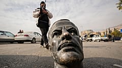 Боевик рядом с разбитым бюстом Хафеза Асада, отца и предшественника Башара Асада, Дамаск, 8 декабря 2024 года.